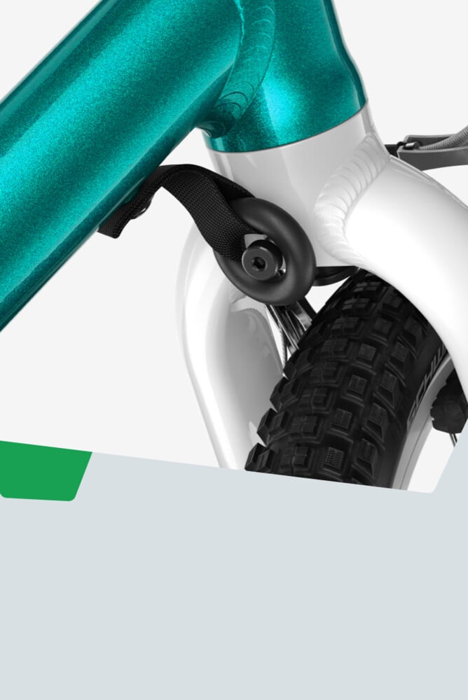 Detaljbild av styrutslagsbegränsaren på en turkosfärgad woom GO-cykel