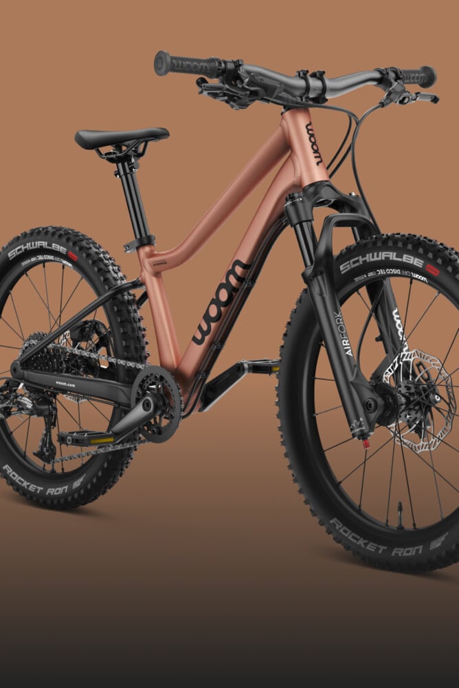 Seitliche Frontansicht des Kindermountainbikes woom OFF AIR mit Federgabel in der Farbe terra coppa.
