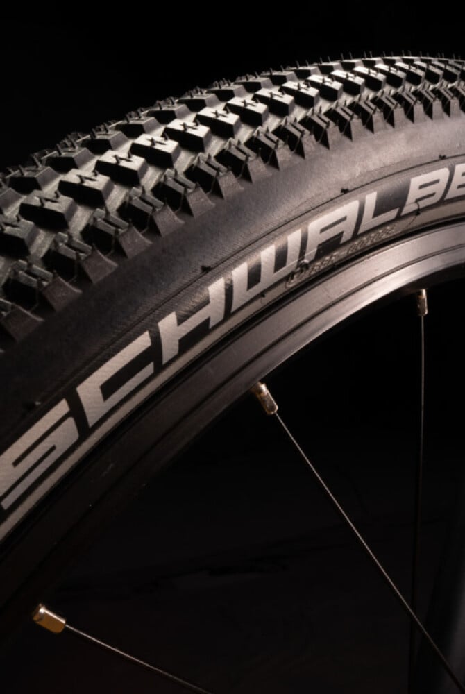 Nahaufnahme eines schwarzen Fahrradreifens am woom EXPLORE Kinderfahrrad mit weißem Schwalbe-Schriftzug auf der Flanke.